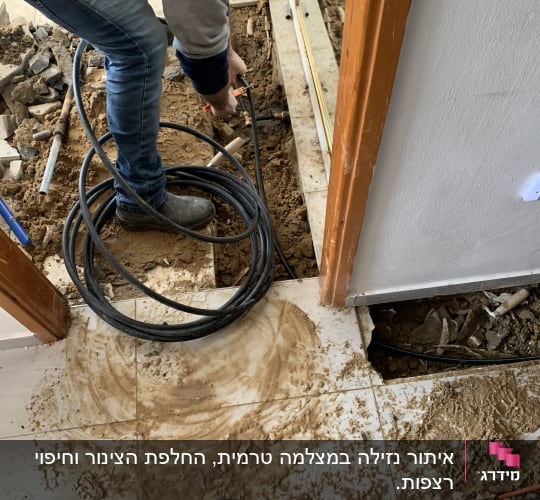 אדם עובד עם צינור וכלי עבודה על רצפה חשופה